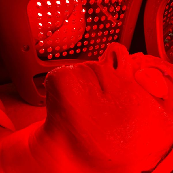 Angel Therapies - Tower Bridge London - Cube Light LED Therapy - image of Angelica receiving treatment - the light is red